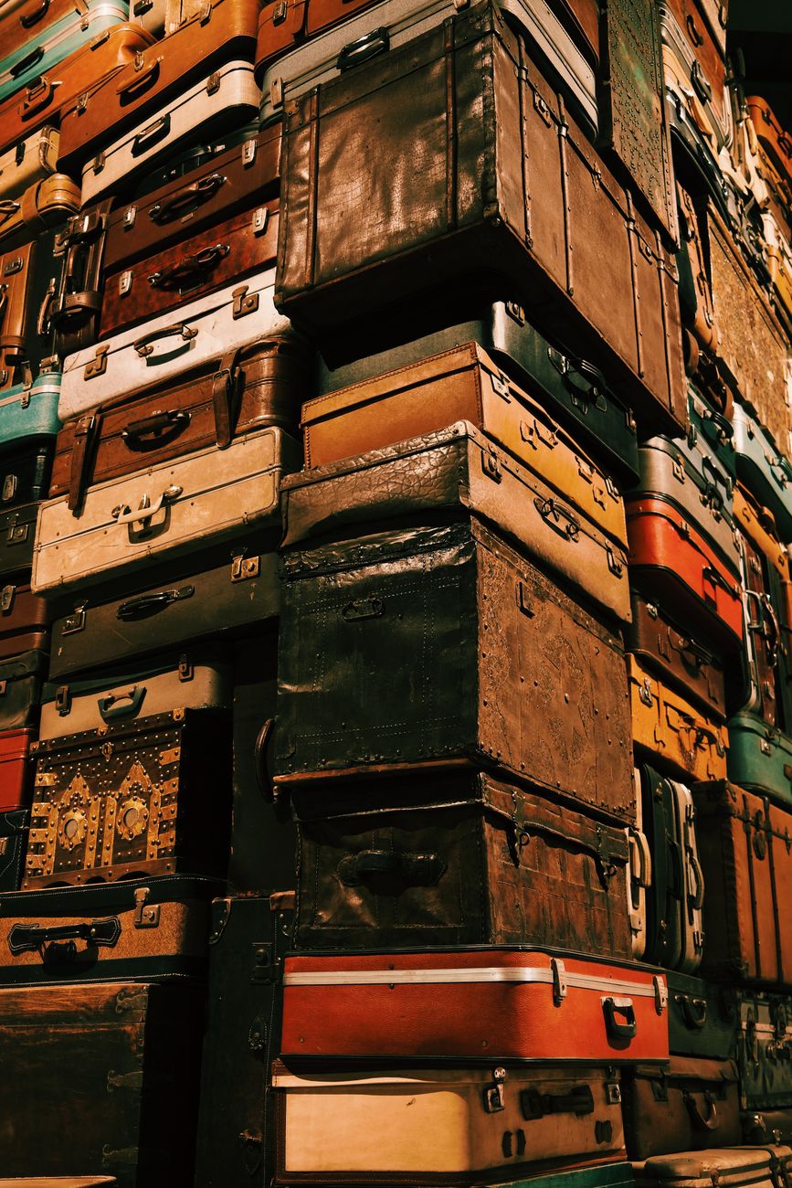 vintage suitcases stacked in towering pile